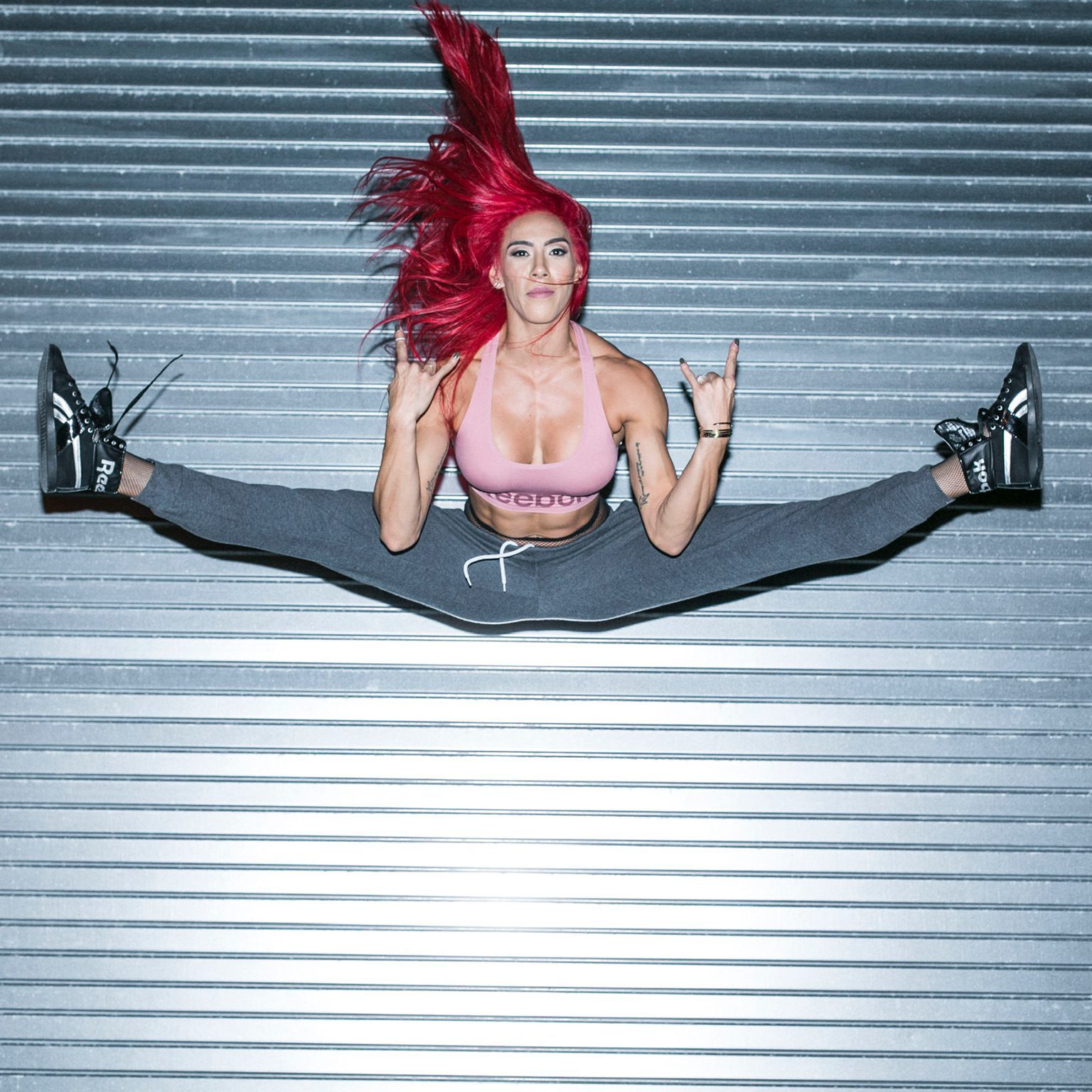 Hannah Eden jumping in front of metal door