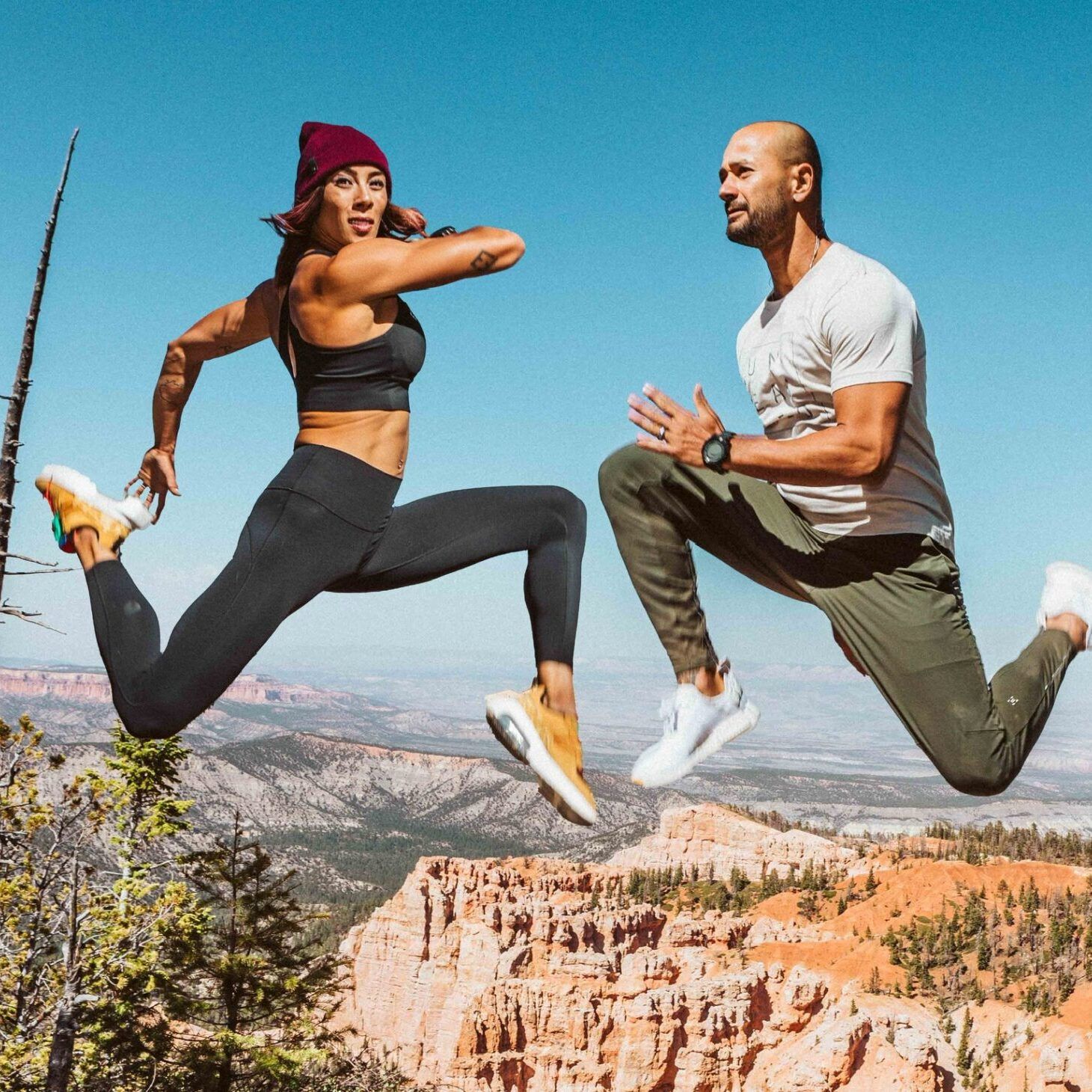 Hannah Eden + Paulo Barreto leaping in the mountains